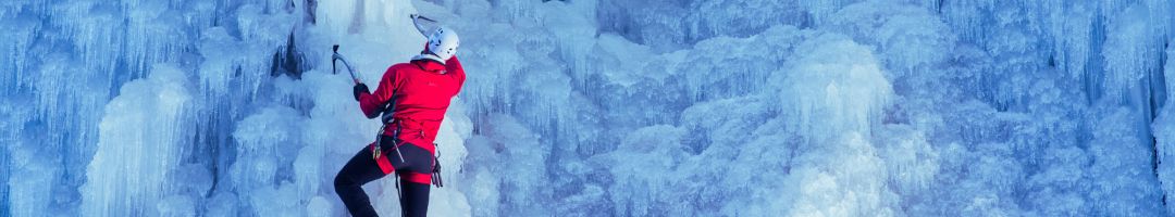 Person mit Eispickel an Eiswand