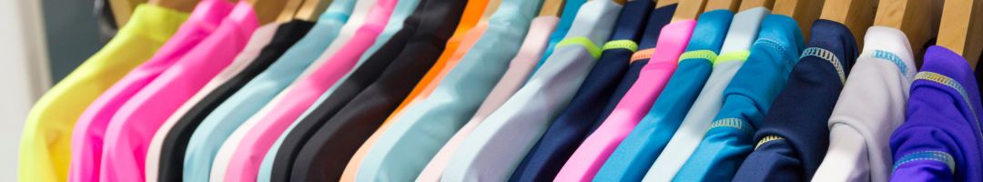 Kleidung in verschiedenen Farben auf Holzbügeln