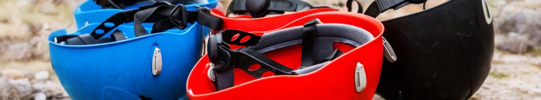 Kletterhelme in verschiedenen Farben auf Fels