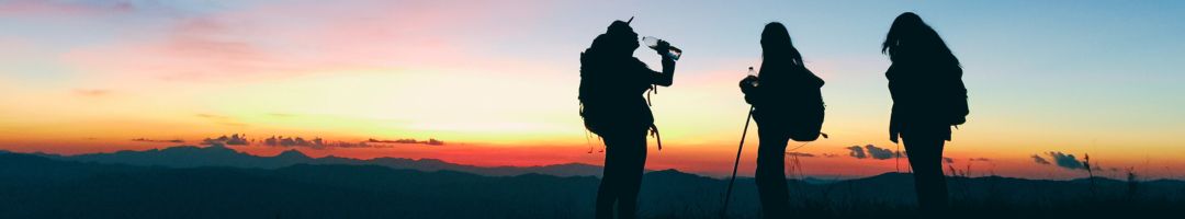 drei menschen vor einem Sonnenaufgang