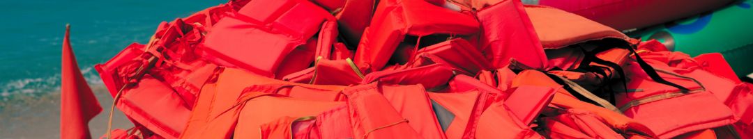 orange und rote Schwimmwesten gestapelt