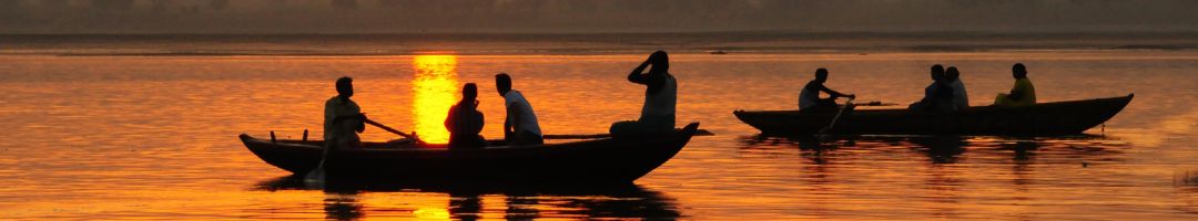 2 Boote mit Menschen bei Sonnenuntergang auf dem Wasser