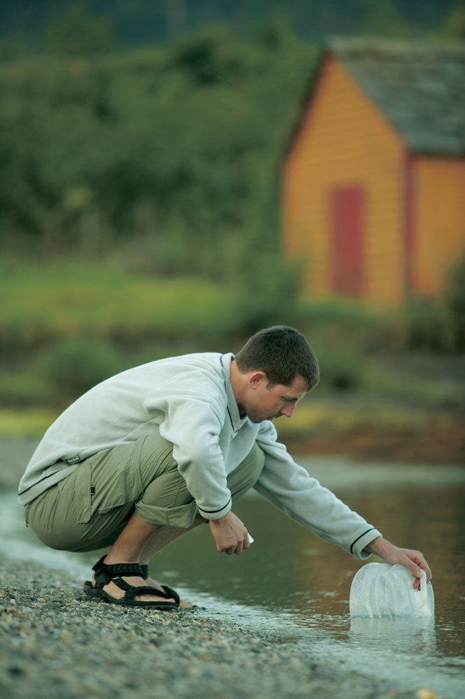 Mann mit Tatonka Faltkanister 5 L – Kompakter, faltbarer Wasserkanister, der Wasser einfüllt