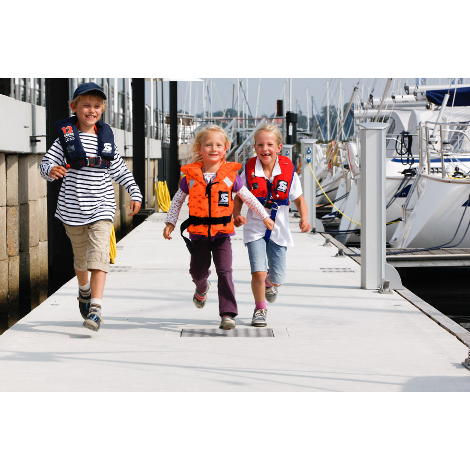 Kinder mit Secumar Bravo Print Kinder Schwimmweste auf Steg