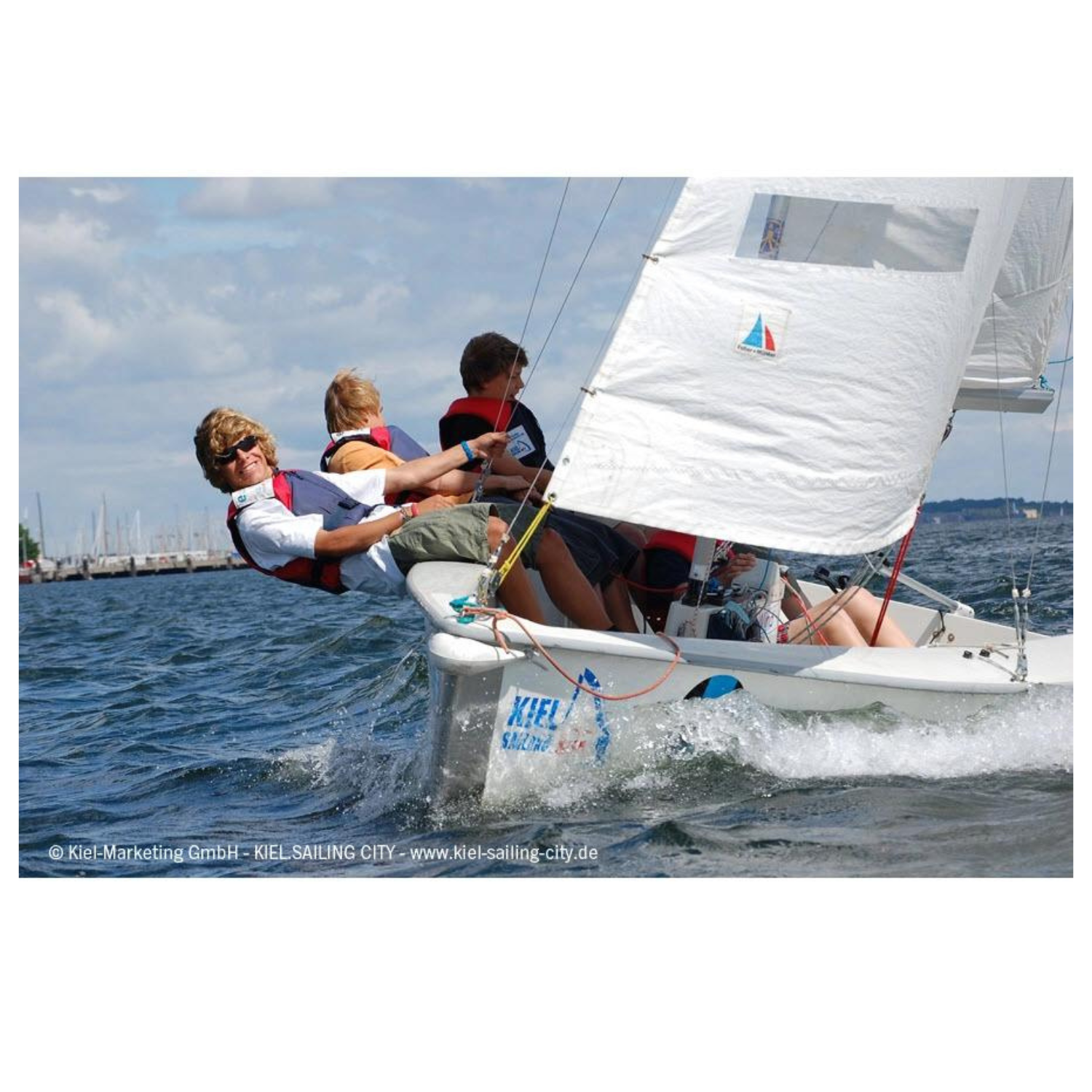 drei Menschen mit Secumar Echo Schwimmhilfe/ Kajakweste blau/ rot auf Segelboot