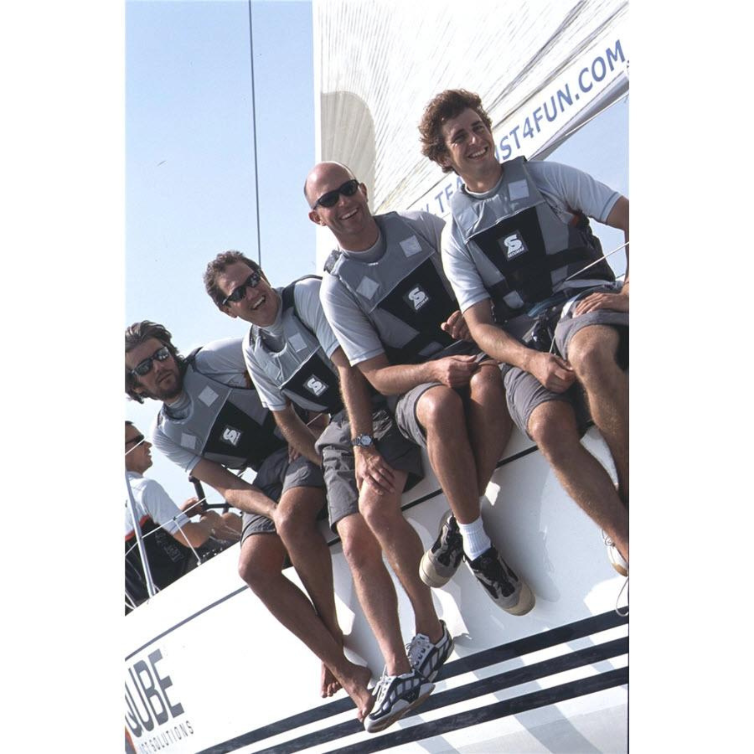 vier Personen sitzen auf Segelboot mit Secumar Jump Schwimmhilfe/Kajakweste, grau