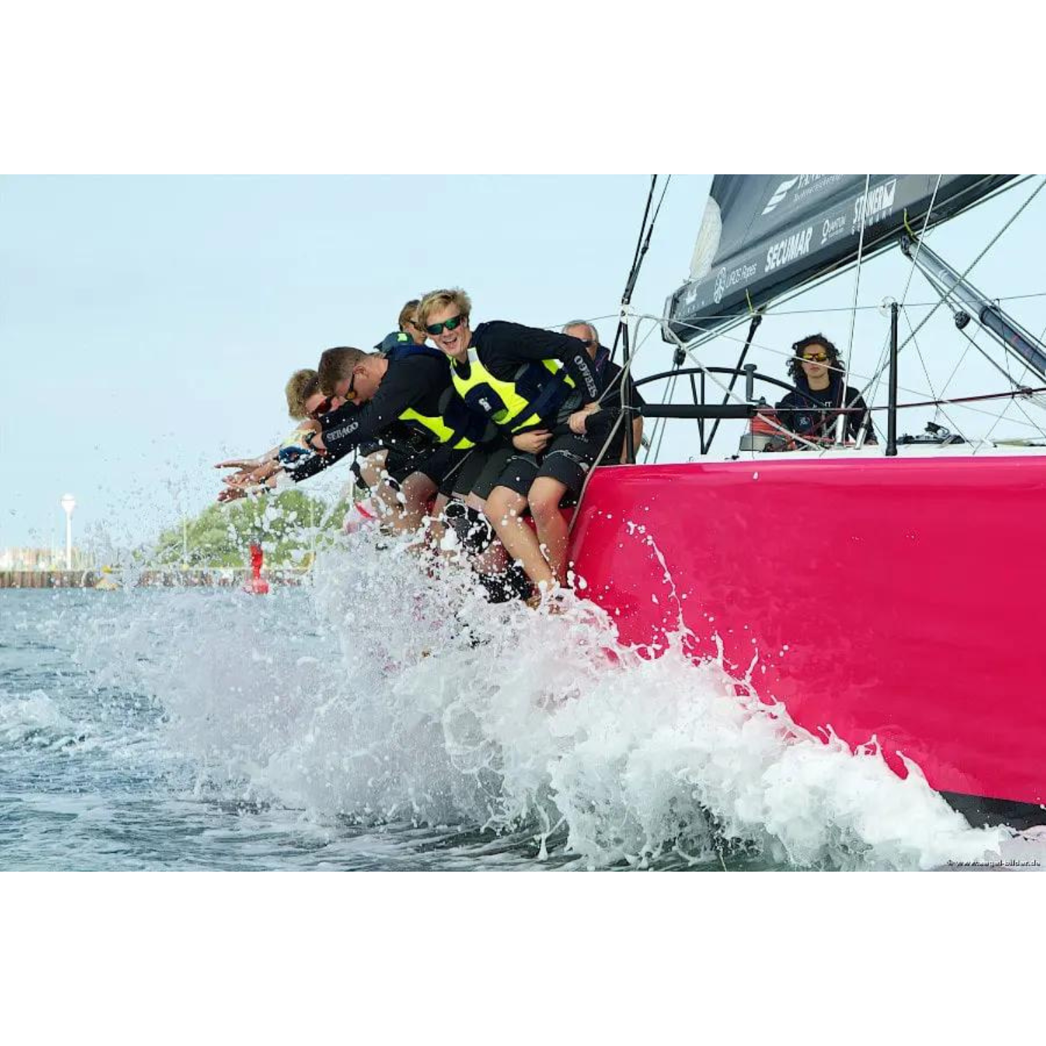 mehrere Personen mit Secumar Jump Pro Schwimmhilfe/Kajakweste gelb schwarz am Bootsrand